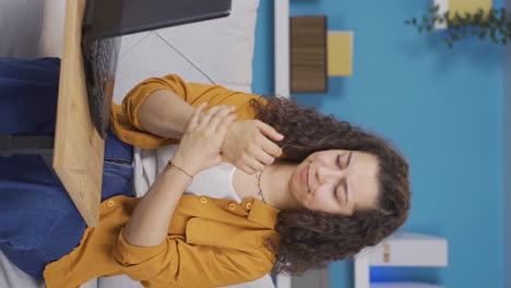 Vertical-video-of-The-wrist-of-the-young-woman-using-a-laptop-hurts.